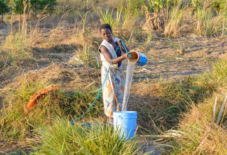 Femme puisant de l'eau dans un puits au Malawi